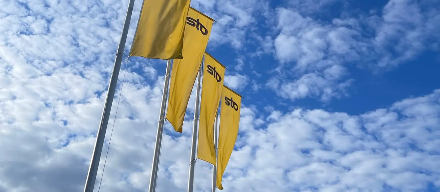 Sto flagg som vaier i vinden mot en blå himmel